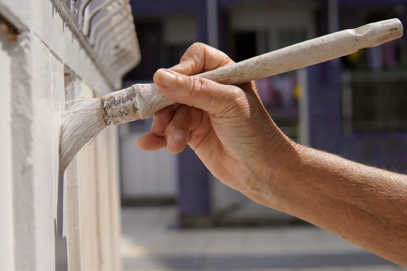 Brushing white paint onto exterior trim