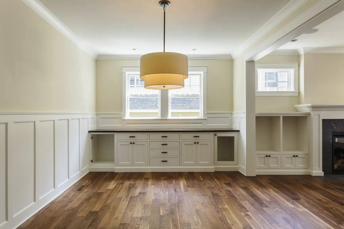 Dining room with freshly painted cream walls, white wainscoting and built-in cabinetry
