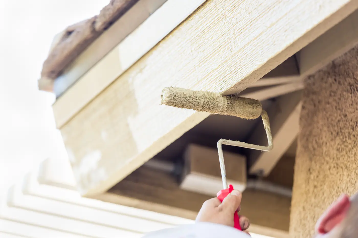 Rolling paint onto an exterior eave